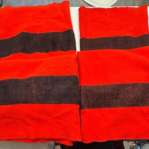 May include: Four red and black striped fabric squares. The fabric is a soft, fuzzy material.