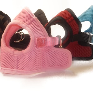 Pu&ograve; includere: Quattro diversi tipi di pettorine per cani di diversi colori con tessuto a rete e cinturini regolabili. Le pettorine sono in mimetico, rosa, rosso e blu.