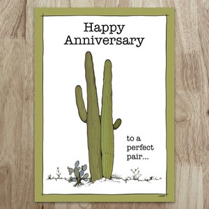 Tarjeta de aniversario caprichosa de Saguaro: un dúo de cactus te saluda desde esta dulce tarjeta. Interior: "Te deseo un año lleno de amor y sol".