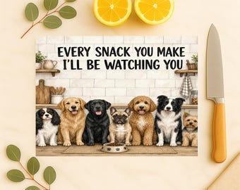 May include: A rectangular kitchen cutting board featuring a kitchen scene with seven dogs sitting in a row and the text "EVERY SNACK YOU MAKE I'LL BE WATCHING YOU" printed above them. The board has a light-colored tile background and a small bowl.