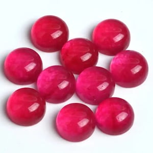 May include: Ten round, pink cabochon gemstones. The gemstones are smooth and have a slight shimmer.