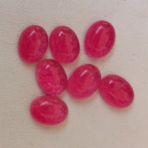 May include: Eight oval-shaped, pink cabochon gemstones. The stones are translucent and have a slightly cloudy appearance.