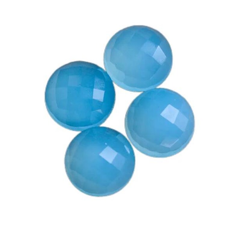 May include: Four round, light blue gemstone cabochons with a faceted finish.