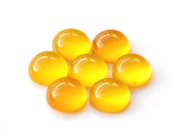 May include: Eight round, yellow cabochon gemstones. The gemstones are smooth and polished.