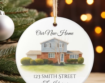 May include: A white ceramic Christmas ornament with a watercolor painting of a house. The text "Our New Home", "123 SMITH STREET", "The Johnsons", and "2025" are printed on the ornament. The ornament hangs from a natural twine.