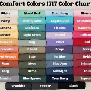 May include: A color chart displaying a variety of Comfort Colors 1717 t-shirt hues. The chart includes colors like white, island reef, chambray, and blossom. Each color is labeled with its name, offering a comprehensive palette for apparel selection.
