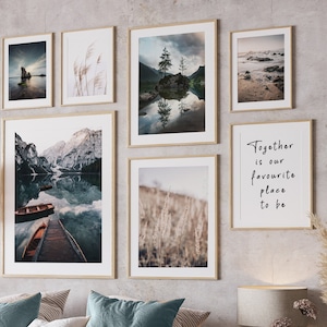 Puede incluir: Un interior de dormitorio con una cama, una mesita de noche y una galería de pared de impresiones enmarcadas. Las impresiones presentan escenas de la naturaleza, incluyendo un lago con montañas, un campo de hierba alta y una playa rocosa. El texto "Together is our favourite place to be" está impreso en uno de los marcos.