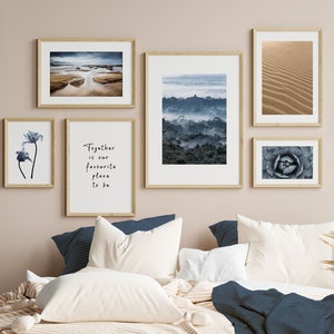 Puede incluir: Un interior de dormitorio con una pared de color marrón claro y una cama con ropa de cama blanca y azul. Hay seis impresiones enmarcadas en la pared, incluida una impresión con el texto "Together is our favourite place to be".