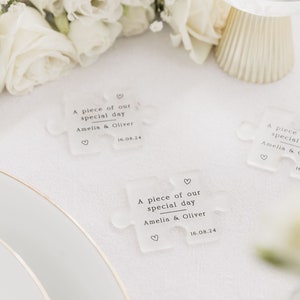 May include: Three clear acrylic puzzle pieces with the text "A piece of our special day Amelia & Oliver 16.08.24" printed on each piece.