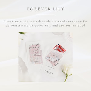 Puede incluir: Tarjetas de rascar para bodas con los textos "Lucky in Love" y "We're so lucky to have you with us." Las tarjetas est&aacute;n en fundas transparentes, con un dise&ntilde;o rojo y blanco. El texto "Forever Lily" est&aacute; en la parte superior.