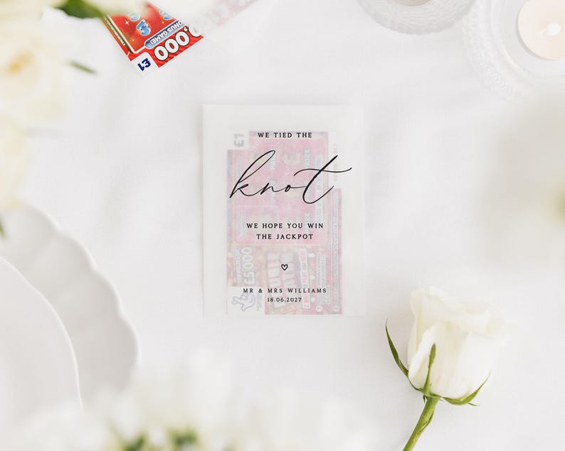 Puede incluir: Un recuerdo de boda con un billete de loter&iacute;a dentro de un sobre transl&uacute;cido. El sobre dice "WE TIED THE knot" y "WE HOPE YOU WIN THE JACKPOT". La fecha "18.06.2027" y los nombres "MR & MRS WILLIAMS" tambi&eacute;n est&aacute;n impresos.