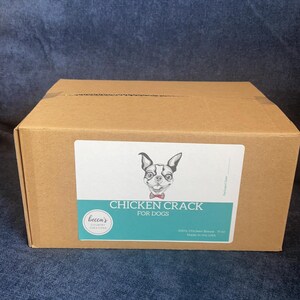 Puede incluir: Una caja de cart&oacute;n marr&oacute;n con una etiqueta que dice "Chicken Crack for Dogs". La etiqueta presenta una ilustraci&oacute;n en blanco y negro de un perro. La caja contiene 312 gramos de pechuga de pollo.