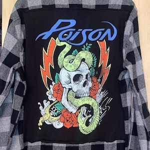 May include: Black and gray plaid flannel shirt with a black patch on the back featuring a skull, snake, and roses with the word "Poison" in blue lettering.