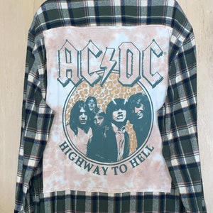 May include: Green and white checked flannel shirt with a tie-dye patch on the back featuring the band AC/DC and the text "Highway to Hell".