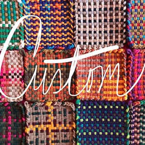 May include: A collection of colourful woven squares with "Custom" written across the centre in white.
