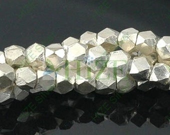 May include: A strand of silver-toned metal beads, each bead is faceted and has a geometric shape.