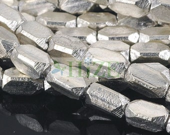 May include: A close-up of a pile of silver-toned metal beads. The beads are faceted and have a hexagonal shape.