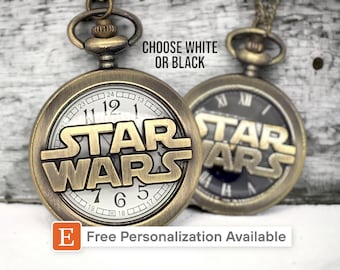 May include: A gold-tone pocket watch with a white face and the words "STAR WARS" in raised lettering. The watch has a chain attached to it. The text "CHOOSE WHITE OR BLACK" is visible above the watch.