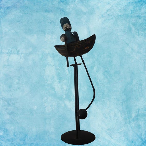 A carved folk-art canoe man that rocks and balances via pendulum — the kind of whimsical, hand-carved kinetic toy that feels genuinely vintage and totally one-of-a-kind.