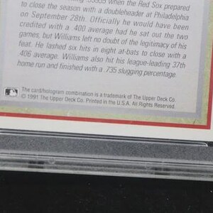 May include: A baseball card encased in a clear plastic holder. The card has text in black font on a white background with a red border. The Upper Deck Co. trademark is visible.