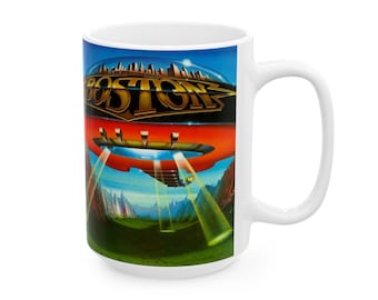 May include: White ceramic mug with a colorful image of a flying saucer and the word "BOSTON" in gold letters. The saucer is over a green field with mountains in the background.