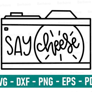 May include: Black and white line art illustration of a camera with the words "SAY cheese" written inside the viewfinder.