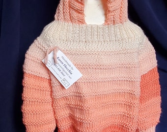 Size 18 month knitted baby Hooded Sweater with zipper in back and mittens attached to a draw string in variegated peach colors.