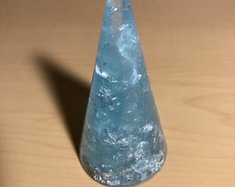 May include: A light blue glass ring holder shaped like a cone with silver glitter embedded in the glass.