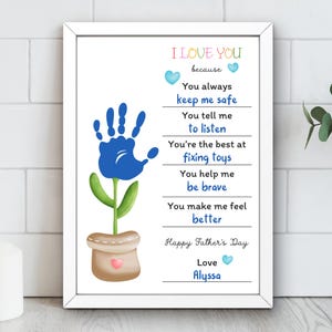 Puede incluir: Una impresi&oacute;n enmarcada con borde blanco presenta un dise&ntilde;o de flor de huella de mano azul. El texto incluye "I Love You" y las razones, junto con "Happy Father's Day" y "Love Alyssa."