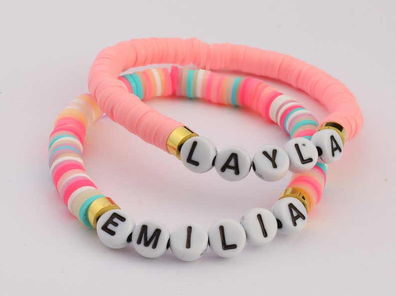 May include: Two colourful beaded bracelets with the names "Layla" and "Emilia" spelled out in white letters.