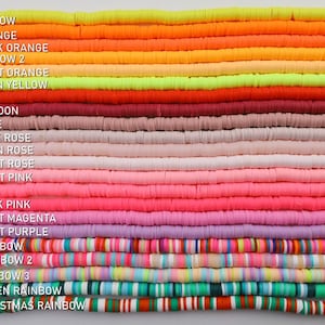 May include: A collection of 21 different coloured polymer clay beads, arranged in rows. The beads are all the same size and shape, and they are all flat and round. The colours of the beads include yellow, orange, red, pink, purple, and green. The beads are labelled with numbers and names, such as "Yellow", "Orange", "Red", "Pink", "Purple", and "Green".