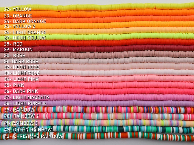 May include: A collection of 21 different coloured polymer clay beads, arranged in rows. The beads are all the same size and shape, and they are all flat and round. The colours of the beads include yellow, orange, red, pink, purple, and green. The beads are labelled with numbers and names, such as "Yellow", "Orange", "Red", "Pink", "Purple", and "Green".