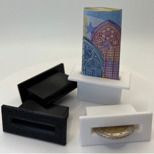 May include: Two black and two white plastic money holders with slots for bills and coins. One holder has a euro bill inserted and another has a euro coin inserted.