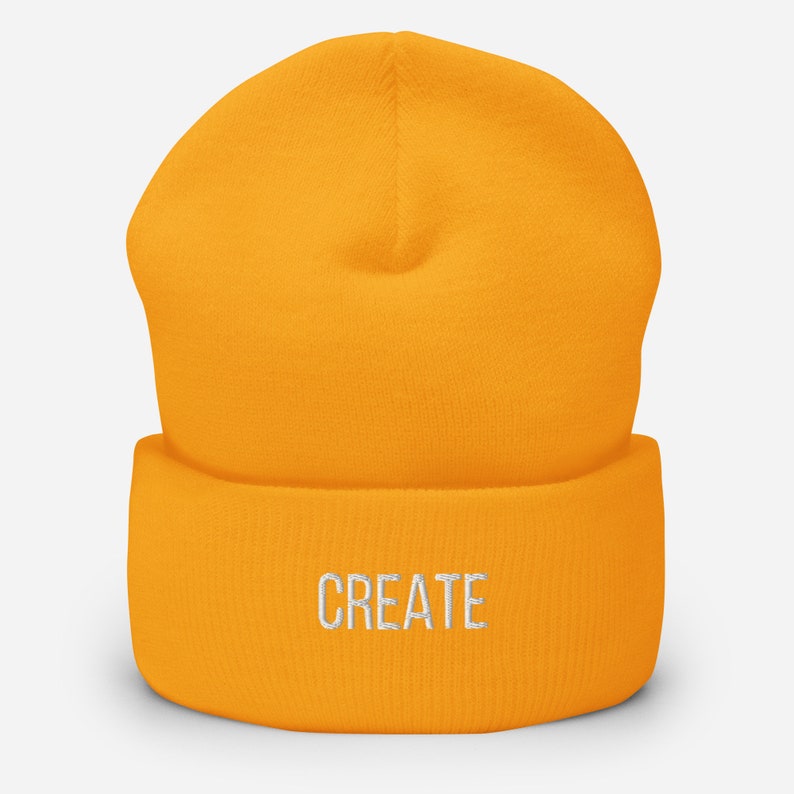 Puede incluir: Un gorro amarillo brillante con la palabra "CREATE" bordada en blanco en la parte delantera.