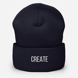 Puede incluir: Un gorro azul marino con la palabra "CREATE" bordada en blanco en la parte delantera.