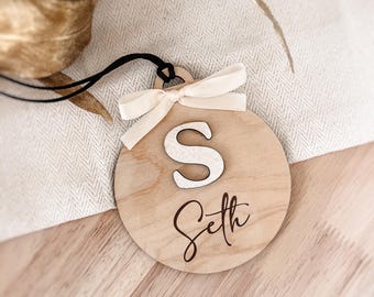 Gepersonaliseerde kerstbal met voornaam en initiaal in reliëf met gouden of zilveren glitters