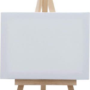 May include: A small wooden easel with a white canvas. The easel has a simple design with three legs and a rectangular base.