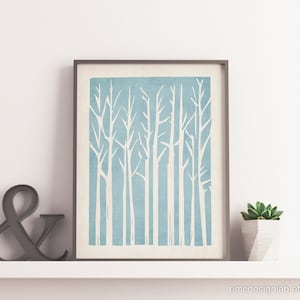 Puede incluir: Una impresión enmarcada de una escena de bosque minimalista en azul y blanco. La impresión presenta un diseño estilizado de árboles con troncos y ramas blancas sobre un fondo azul claro.