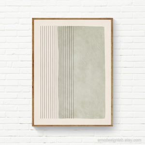 May include: A framed wall art print featuring a cream-colored background with a series of thin, vertical black lines on the left side and a large, textured sage green rectangular block occupying the right side of the composition.