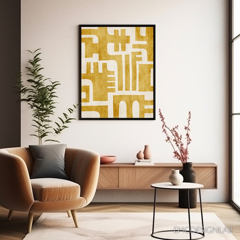 May include: A framed abstract print with a white background and a geometric design in a mustard yellow color.