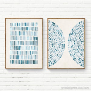 Könnte beinhalten: Zwei gerahmte abstrakte Kunstdrucke mit einem geometrischen Muster in Blau und Weiß. Der Druck auf der linken Seite hat ein Gittermuster, während der Druck auf der rechten Seite ein Halbkreis-Muster hat.