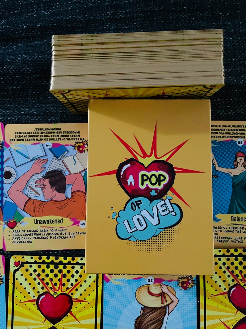 Peut inclure: Un jeu de cartes avec une bo&icirc;te jaune orn&eacute;e d'un c&oelig;ur rouge et du texte A POP OF LOVE. Les cartes pr&eacute;sentent des illustrations de style bande dessin&eacute;e, incluant une personne au repos, un personnage au chapeau et divers motifs de c&oelig;urs.