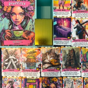 May include: A tarot card deck called "graffiTEA" with a box showing a woman with floral hair holding a teacup. The deck includes cards with illustrations and text, such as "VIBE ABOUT IT volume 3". The cards have various themes.