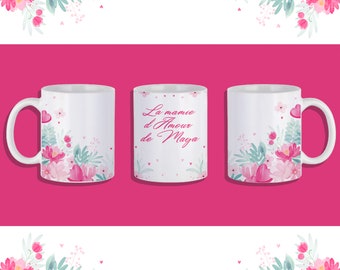 May include: Three white ceramic mugs with a floral design and pink hearts. The mug in the center has the text "La mamie d'Amour de Maya" in pink.