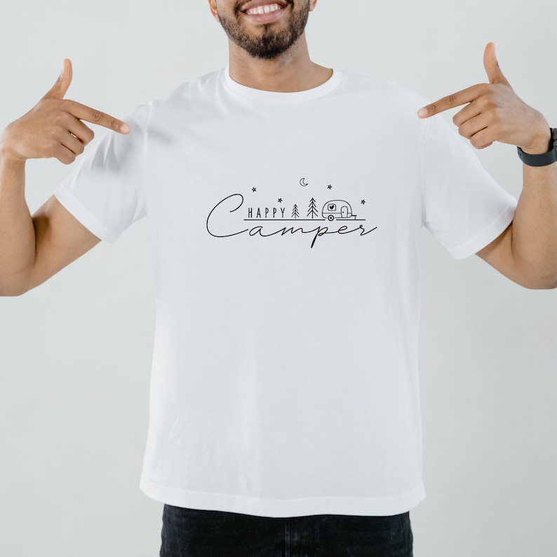May include: White t-shirt with a black graphic design that says "Happy Camper" with a camper, trees, and stars.