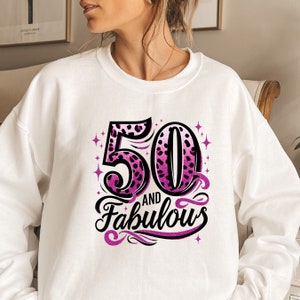 May include: White sweatshirt with a pink and black leopard print design that says "50 and Fabulous".