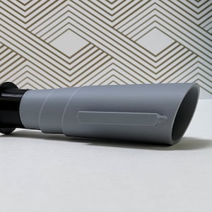 May include: A gray plastic telescope with a black end cap. The telescope is about 10 inches long.