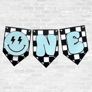 May include: Black and white checkered banner with the word "ONE" in light blue. The "O" is a smiley face with lightning bolts for eyes.