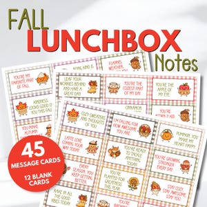 May include: A collection of 45 rectangular lunchbox message cards and 12 blank cards featuring autumn-themed illustrations like pumpkins, leaves, and acorns. Each card displays encouraging text in red and green, set against a checkered border.