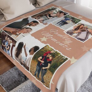 May include: A soft, peach-colored fleece blanket with a collage of family photos and the text "Family Moments" in a white script font. The blanket is decorated with gold stars.